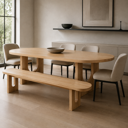 A light natural wood dining table with a matching bench and upholstered dining chairs in a minimalist, warm-toned dining room.