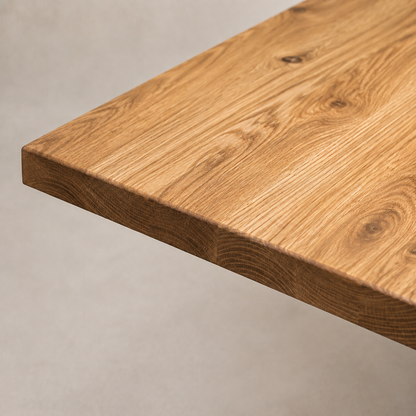 Close-up of a natural oak wood tabletop corner showing the grain and finish against a neutral light gray background.