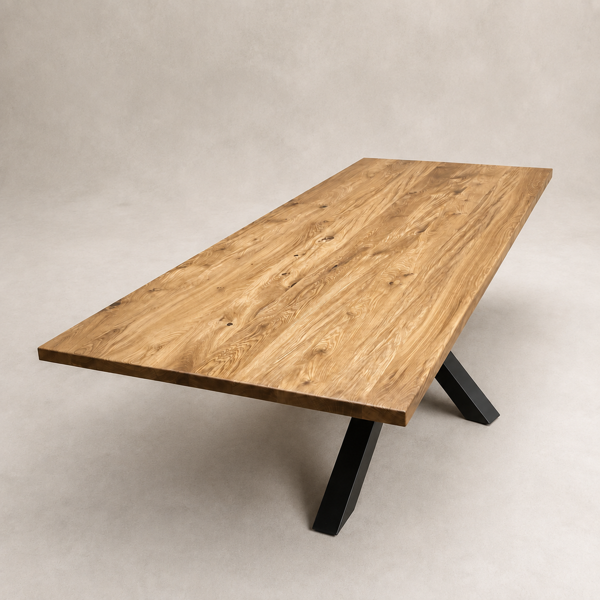A rectangular wooden dining table with a natural oak grain top and black metal A-frame legs, photographed on a neutral textured gray studio background.