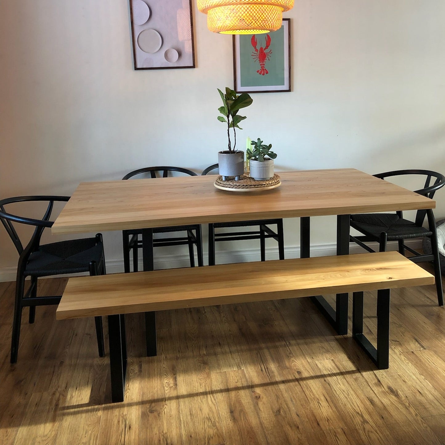 Dining area with wooden table, chairs, and bench under a pendant light.