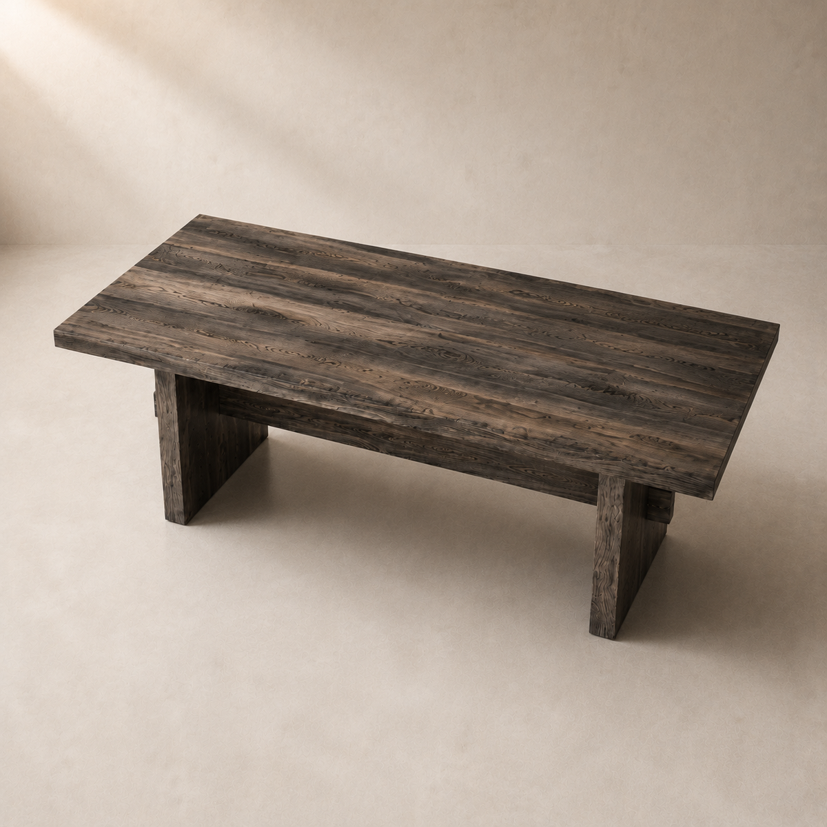 A rustic rectangular wooden coffee table with a dark weathered finish and block-style legs, photographed in a minimalist studio setting with a warm beige background.