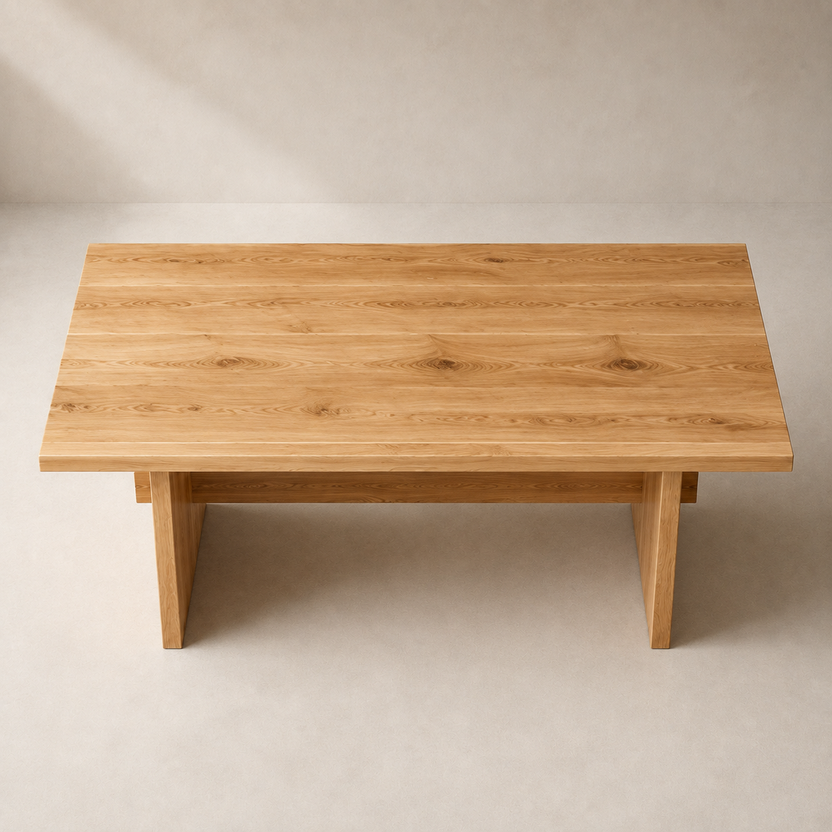 A rectangular wooden dining table with a natural oak finish, featuring a thick top and sturdy legs, photographed from a top-down angle against a neutral beige background.