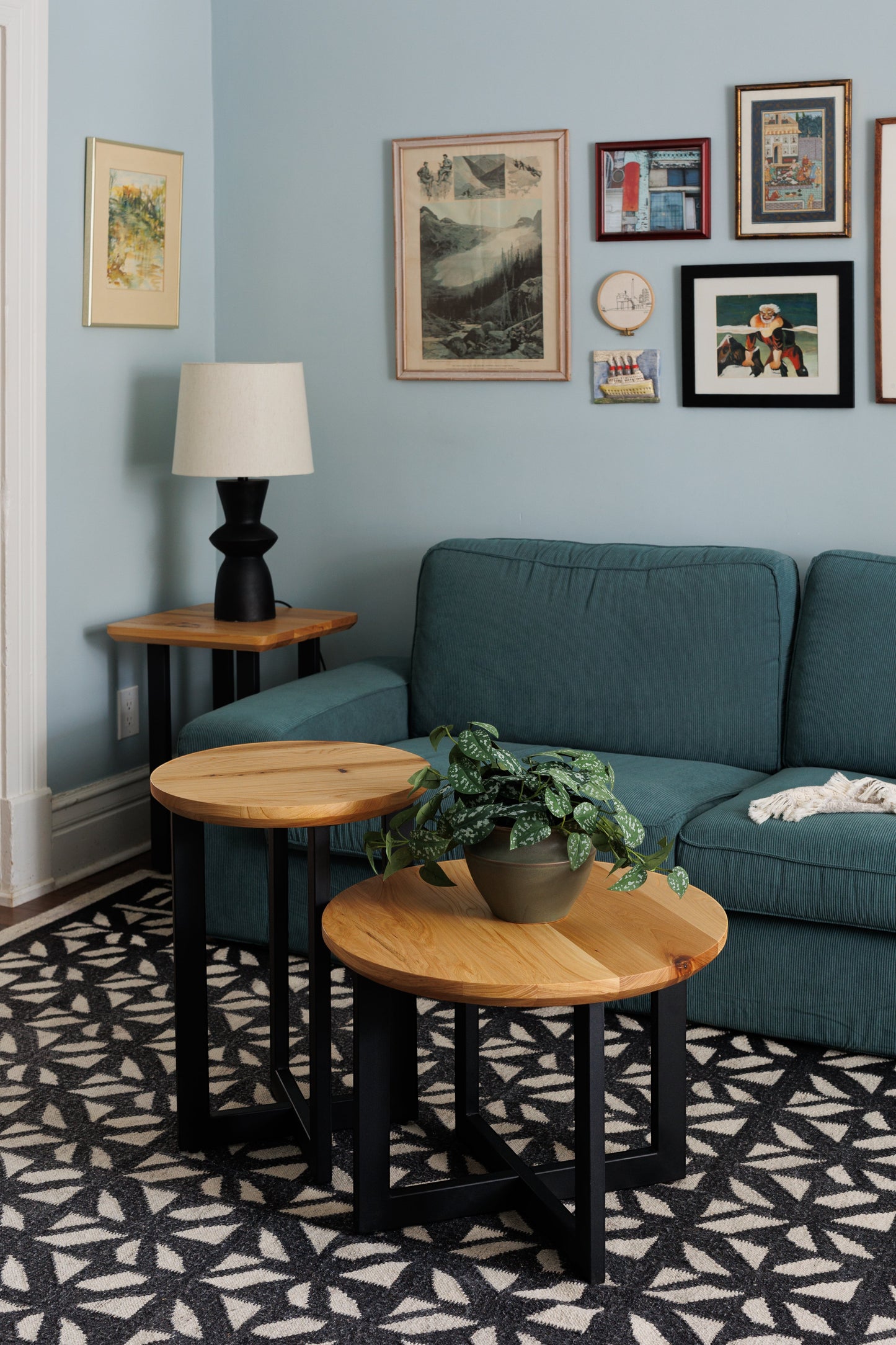 Urban Lumber round coffee table made from salvaged elm wood with natural character and black metal legs.